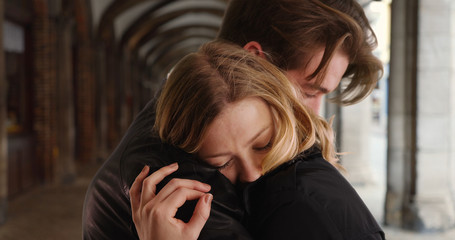 Close up of young attractive husband and wife hugging