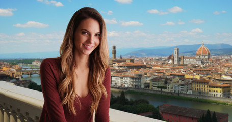 Smiling woman in Florence relaxing outside with view of cityscape
