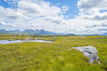 Panorama of mountains, marshy land and heathland of Connemara National Park in summer