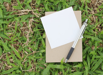 Pen and Notepad on grass background
