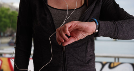 Close up of mature female jogger using activity tracker