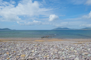 Beach along the atlantic ocean below a blue cloudy sky in summer
