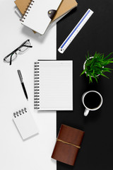 Notebook with coffee cup on black and white background.