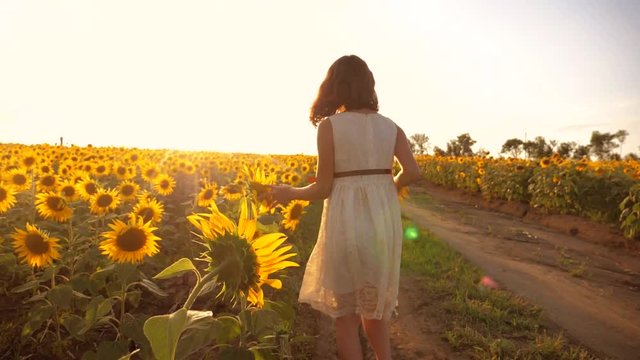 little girl running across the field with sunflowers at sunset. slow motion video. girl runner in lifestyle the field at sunset sunflowers. girl sunlight runs the concept of sunflowers