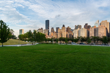 Fototapeta na wymiar New York City / USA - JUL 31 2018: Midtown Manhattan buildings, skyscrapers and apartments view from Roosevelt Island at sunrise