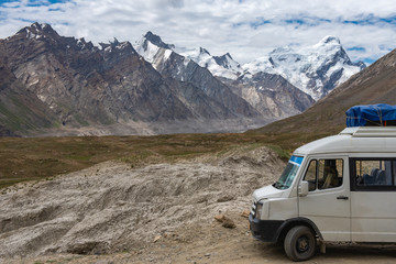 Obraz premium Beautiful landscape of Penzi la pass with a van car and suitcase in summer on the way of Zanskar valley road , Ladakh, India.