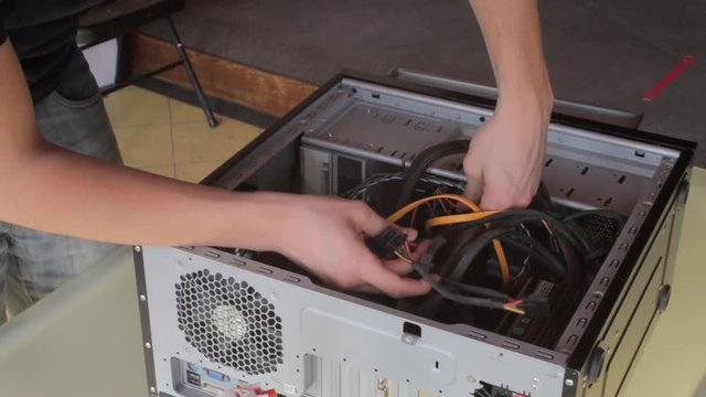 Moving cables around inside a computer as it's built.