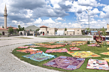 Colourful carpets on grass in Derinkuyu ancient city