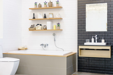 Fototapeta na wymiar Modern bathroom interior with minimalistic shower and lighting, white toilet, sink and bathtub
