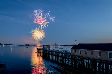 Fireworks on Boothbay Harbor, Maine, reflect off the water on July 4th for Independence Day...