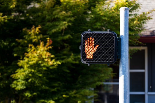 Crosswalk hand symbol sign on a post