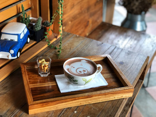 Top view cute pig face latte art cup on the wooden table in the morning , coffee time with yourself, Coffee lover.vintage style