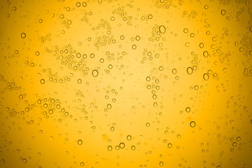 Water drops on yellow glass, Rain droplets on glass background.