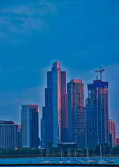 Fototapeta premium Sunset casts warm red glow off of reflective skyscrapers in downtown Chicago.