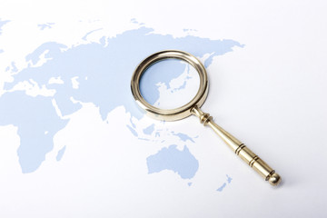 golden magnifier with blue world map