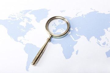 golden magnifier with blue world map