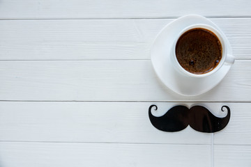 Moustache photo booth props next to cup of coffee on the white background. Moustache cut outs. Movember Movement. Prostate Cancer Awareness, Men's health awareness, father's day concept. 