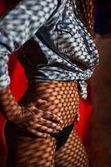 Shadows in the form of small squares fall on the body of a undressing girl