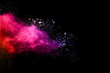 Obraz premium abstract colored dust explosion on a black background.abstract powder splatted background,Freeze motion of color powder exploding/throwing color powder, multicolored glitter texture.