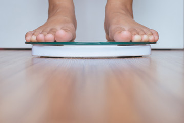 Woman foot standing on weigh scales,Selective focus
