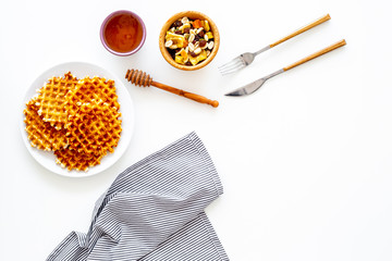 Traditional belgian waffles with dried fruit, nuts and caramel on white background top view copy space