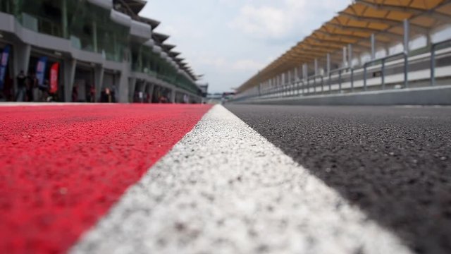 CAMERA FOCUSING IN TO OUT ON RACING CIRCUIT TARMAC