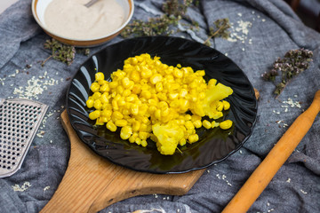 Cooked corn kernels grain on black glass plate. Vegan lunch, vegetarian dinner. Healthy dietary food