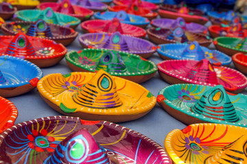 Fototapeta na wymiar Multicoloured Traditional Mexican Sombrero Hat Ashtrays on Tepotzlan Market Stall.