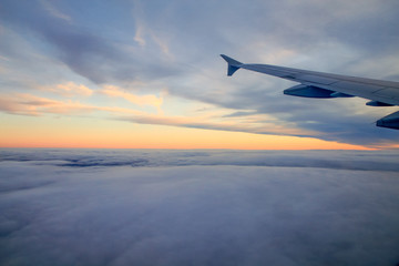 High Altitude Sunset over the Clouds from a Plane Window.