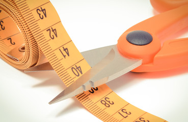 Scissors with tape measure on white background, slimming concept