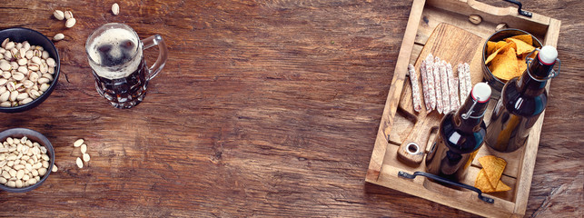 Beer and snacks on wooden background