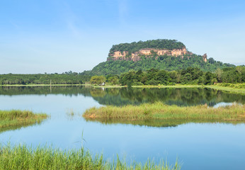 Fototapeta na wymiar View of wat Phuthok or wat Jatiyakeeree viharn on cliff high mountain reflection on the water in lake with blu sky at Bueng Kan Province, Thailand 