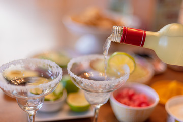 pouring a margarita into glass