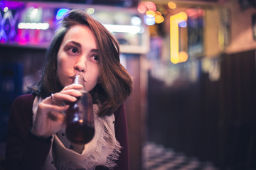 A joyful girl drinking in a bar. This photo represents social interactions and a comum social life