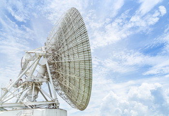 Big large white satellite dish turn up skyward on blue sky in earth communication antenna system...