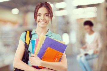 Young smiling woman holding blue notebook