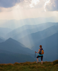 The view with the high mountains in fog. The sun rays are enlighten the forests. The extreme girl...