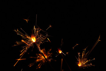 Close up several firework sparklers over black