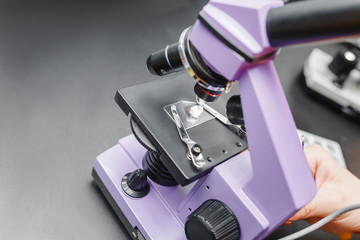 Close-up shot of electronic microscope with stone mineral at laboratory.