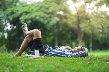 full length happy smiling man lying and relaxing in park