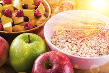 Raw oats in bowl and fruit salad