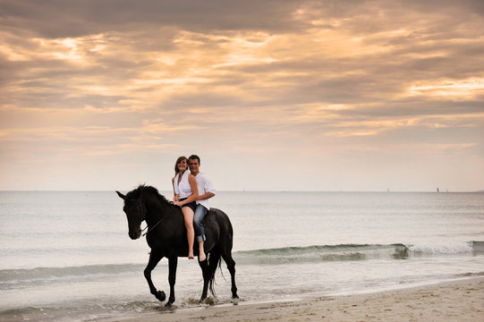 couple and horse on the beach