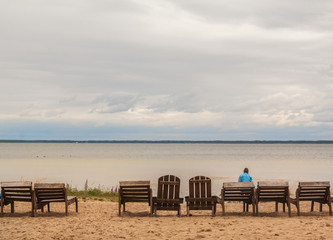 Old wooden sunbeds under a cloudy sky