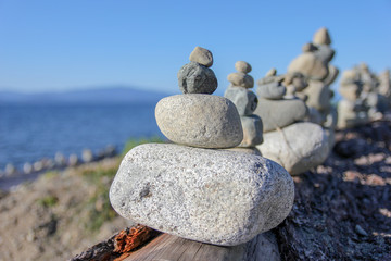 Rocks stacked up on a log at the beach