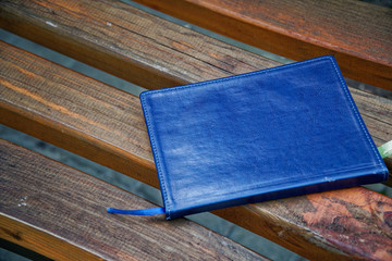Notebook on bench in park, business concept