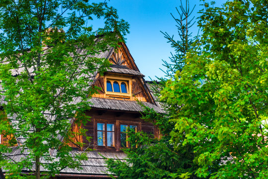 wooden house among the trees on a sunny day, blue sky