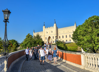 Lublin, Poland - August 11, 2017: The Royal Castle of Lublin, bridge with tourists and bright blue sky. Lublin is the biggest city in eastern Poland. - obrazy, fototapety, plakaty
