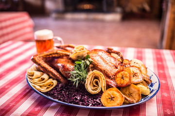 Festive garnished roast duck with apples and red cabbage