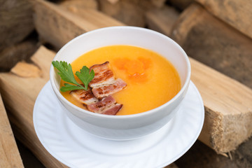 Bowl of pumpkin soup on rustic wooden background. Selective focus
