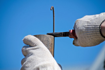 The technician keeps bending the metal rod in his hand with pliers. Pliers in the hands of men....